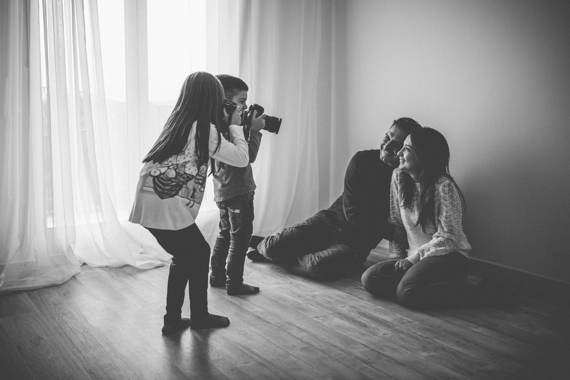 due bimbi che fotografano i loro genitori
